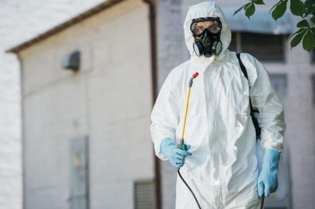 Arizona pest exterminator in white protective suit