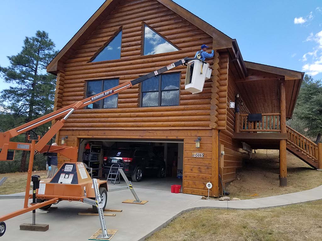 construction worker working on log cabin home - termite exterminators
