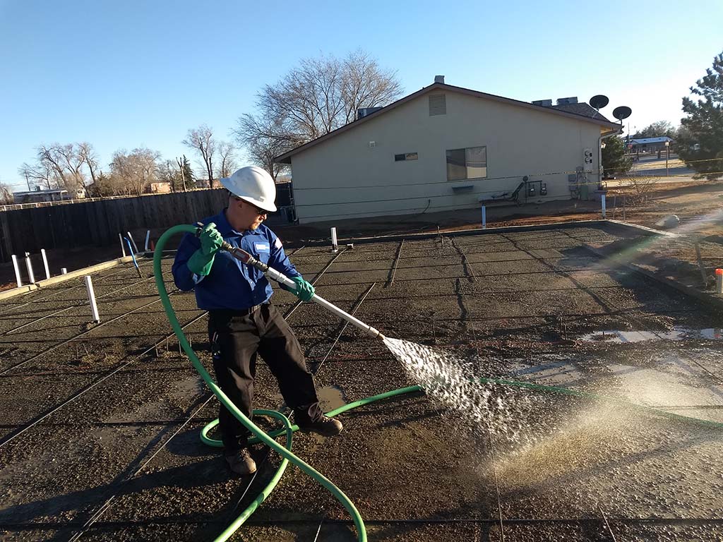 Patriot Pest exterminator sprays ground outdoors