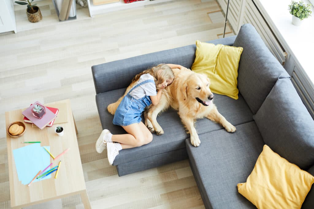 girl asleep with dog in living room